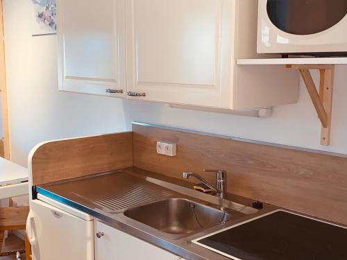 une cuisine avec un évier et un micro-ondes dans l'établissement Appartement cosy pour 5 avec balcon et accès direct aux pistes d'Avoriaz - FR-1-314-256, à Morzine