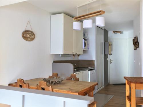 une cuisine avec des armoires blanches et une table en bois dans l'établissement Appartement cosy pour 5 avec balcon et accès direct aux pistes d'Avoriaz - FR-1-314-256, à Morzine