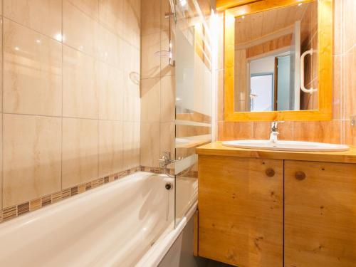 a bathroom with a sink and a tub and a mirror at Appartement Avoriaz, 2 pièces, 5 personnes - FR-1-314-264 in Morzine