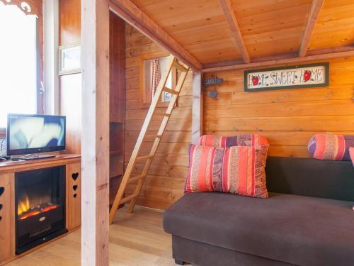 Cette chambre dispose d'un canapé, d'une télévision et d'une cheminée. dans l'établissement Charmant 2 pièces, 5 couchages, centre d'Avoriaz, skis aux pieds, balcon sud, WIFI - FR-1-314-265, à Morzine