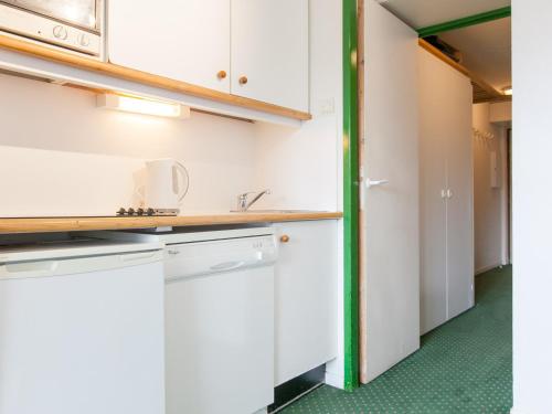 une cuisine avec des armoires blanches et un évier dans l'établissement Appartement pour 5 avec internet près de l'ESF et parking - FR-1-314-267, à Morzine