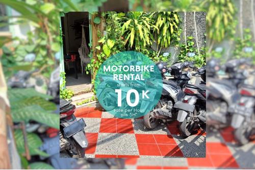 um sinal para uma oficina de motociclistas ao lado de motociclos em Sante Commune Yogyakarta em Yogyakarta