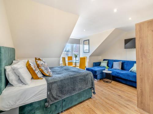 een slaapkamer met een bed en een blauwe bank bij Apartment Six - Uk44288 in Arbroath