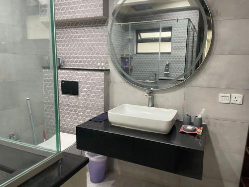 een badkamer met een wastafel en een spiegel bij Grey Orchard Homestay - A Family Place in Lahore