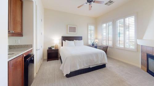 a bedroom with a white bed and a kitchen at LV217 Superb 2 Bedroom Overlooking the Lap Pool in La Quinta