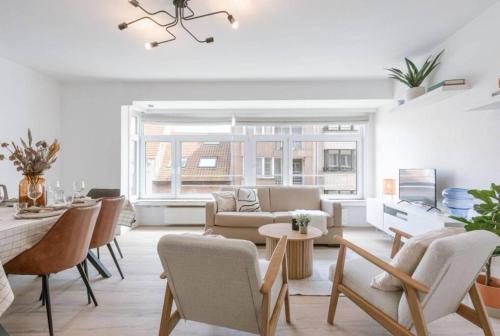 ein Wohnzimmer mit einem Sofa und einem Tisch in der Unterkunft Hugo by the harbor, light-filled and centrally located apartment - free parking in Ostende