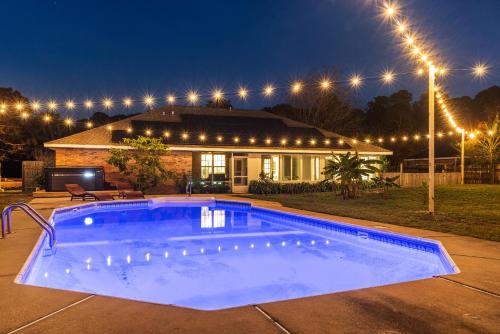 a swimming pool in front of a house at night at Gulf Breeze Beach House w Pool Huge Hot Tub and Sauna in Oriole Beach
