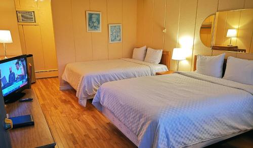 Cette chambre comprend 2 lits et une télévision à écran plat. dans l'établissement Motel Tremblant, à Mont-Tremblant
