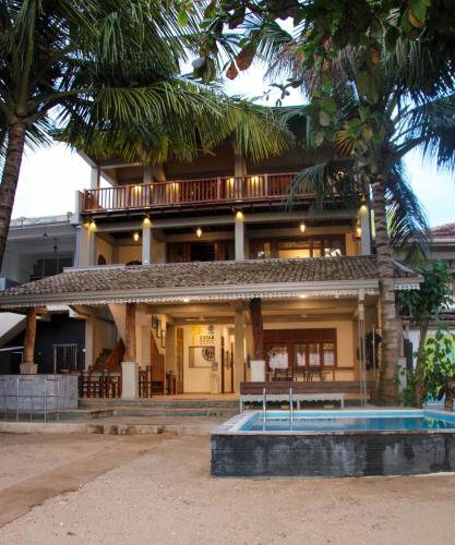 a building with a pool in front of it at Pearl Divers Beachfront Apartment in Unawatuna