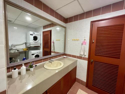 a bathroom with a sink and a large mirror at Kuching City Center Riverbank Suites With Marvelous River View in Kuching