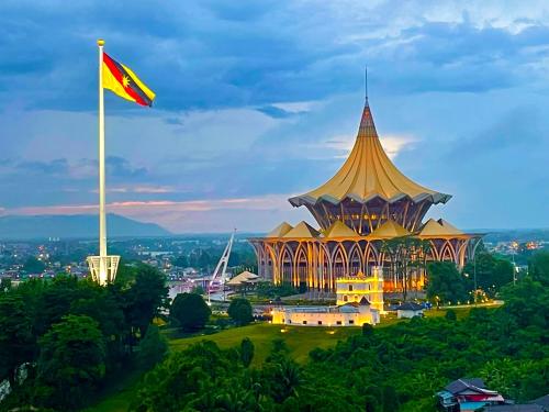 a flag flying in front of a building with a flag at Kuching City Center Riverbank Suites With Marvelous River View in Kuching