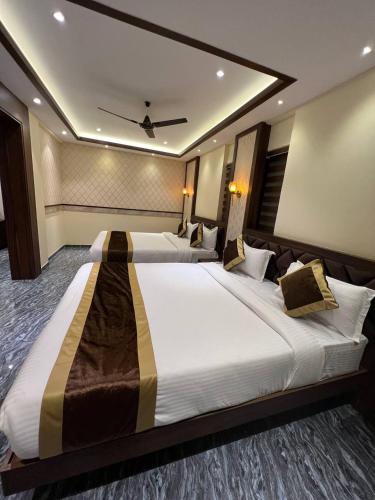a hotel room with two beds with a ceiling at Hotel Mangalore Stay INN in Mangalore