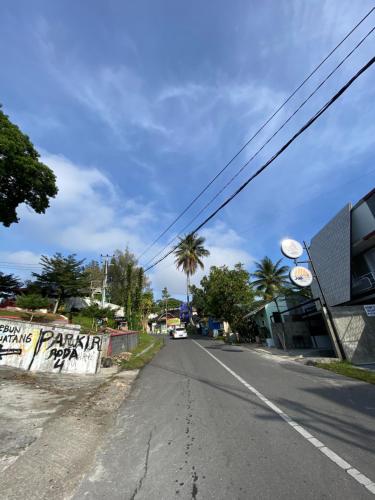an empty street with a sign on the side of the road at OTOUSAN HOUSE in Bukittinggi