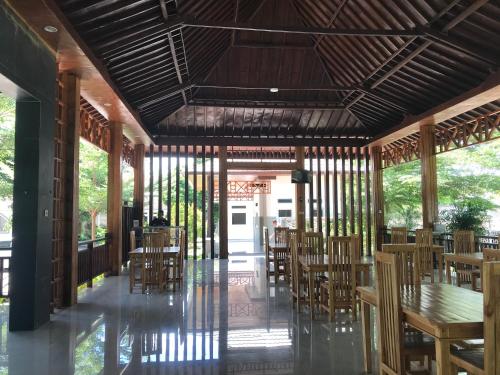 a dining room with wooden chairs and tables at Pohon Purba Resort & Restaurant in Labuan Lombok