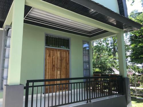 a house with a porch with a wooden door at Pohon Purba Resort & Restaurant in Labuan Lombok