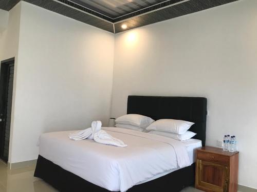 a bedroom with a bed with a towel on it at Pohon Purba Resort & Restaurant in Labuan Lombok
