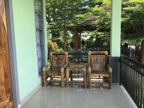 two wicker chairs sitting on the porch of a house at Pohon Purba Resort & Restaurant in Labuan Lombok