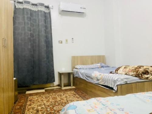 Habitación con 2 camas y ventana en شقة فندقية بالزقازيق, en Az Zaqāzīq