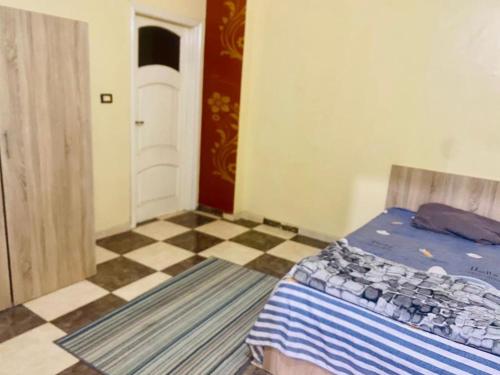 een slaapkamer met een bed en een geruite vloer bij شقة فندقية بالزقازيق in Az Zaqāzīq