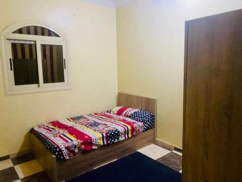 a small bedroom with a bed and a window at شقة فندقية بالزقازيق in Az Zaqāzīq