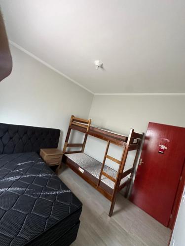 een slaapkamer met een bed en 2 stapelbedden bij Casa na Praia com Piscina - Mongaguá - Drake House in Mongaguá