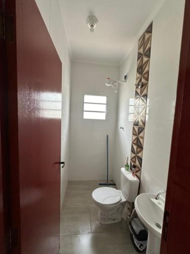 uma casa de banho com um WC e um lavatório em Casa na Praia com Piscina - Mongaguá - Drake House em Mongaguá