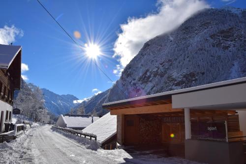 a snow covered mountain with the sun in the sky at Apart Belvita in Sankt Leonhard im Pitztal