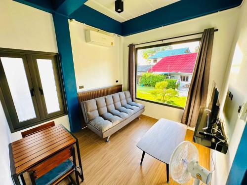 sala de estar con sofá y ventana en The Scenery Beach Resort, en Baan Khai