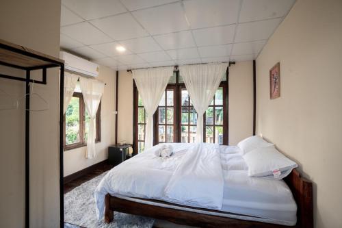 un dormitorio con una cama con un animal de peluche en The woodshed village en Ban Ton Phung