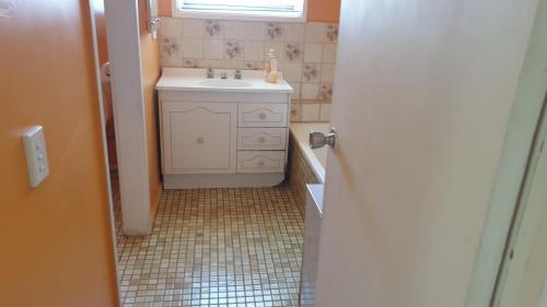 a small bathroom with a sink and a window at Private room with shared facilities W in Werribee