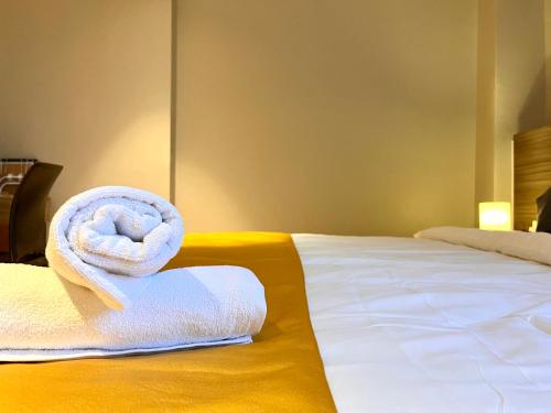 a hotel room with a towel on a bed at HillMark Suites in Ayer Keroh