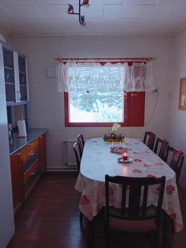 cocina con mesa de comedor y ventana en Talo rantasaunalla en Vaala