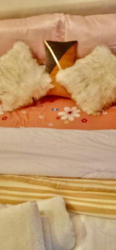 a bed with two pillows and a cat laying on it at Unit 3J Signature Suites, Lafayette Megaworld in Iloilo City