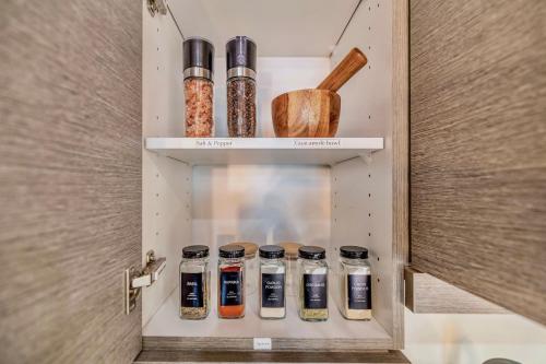 a cupboard with spice jars in it at FREE PARKING 5 Star Quiet 2 BR Loft - Central - FULLY Stocked in Winnipeg
