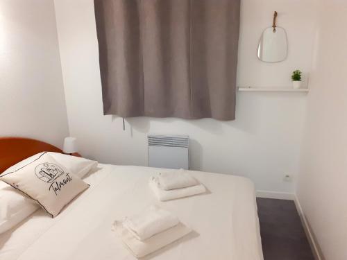 タルモンにあるLes Sens du Veillonのベッドルーム1室(白いベッド1台、白いタオル2枚付)