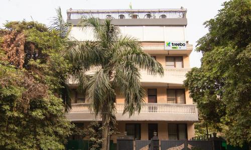 a building with a palm tree in front of it at Treebo Trend Nv in Gurgaon
