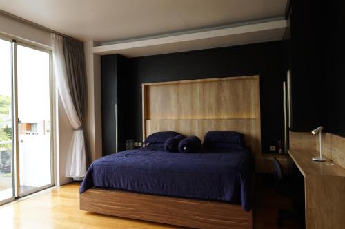 um quarto com uma cama azul e uma cabeceira em madeira em Villa Majesty Dago em Bandung