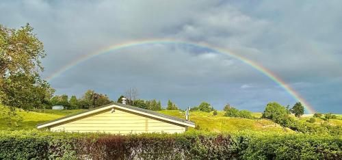 a rainbow in the sky over a house at Hopwood Bed & Breakfast in Taihape