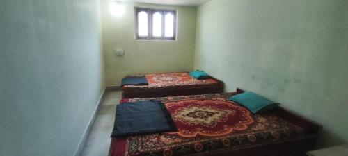 Duas camas num quarto com uma janela em A Budget Inn em Bodh Gaya
