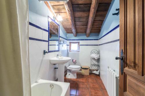 a bathroom with a white toilet and a sink at Casas Rurales Noguericas in Archivel