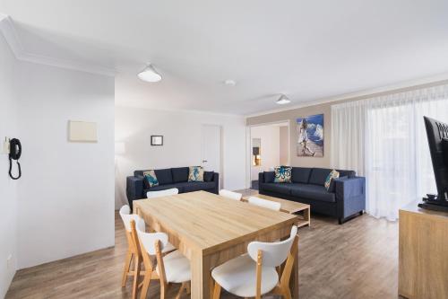 a dining room and living room with a table and chairs at Amalfi Resort in Busselton