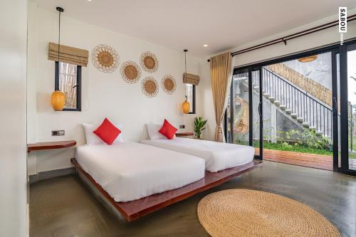 two beds in a room with a balcony at Santaniya Residence in Kampot
