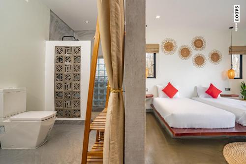 a bedroom with two beds and a bathroom at Santaniya Residence in Kampot