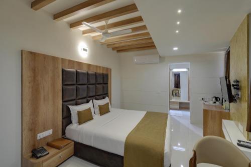 a bedroom with a bed and a desk and a television at Hotel City Inn in Gandhinagar