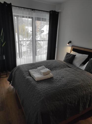 1 dormitorio con 1 cama con 2 toallas en Apartament 9 SzklarSki en Szklarska Poręba