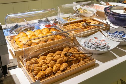 a buffet filled with trays of pastries and other food at Best Western Jeju Hotel in Jeju