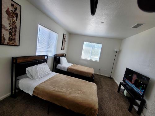 a bedroom with two beds and a flat screen tv at 4 Bedrooms & 2.5 Bathrooms in LA in Los Angeles