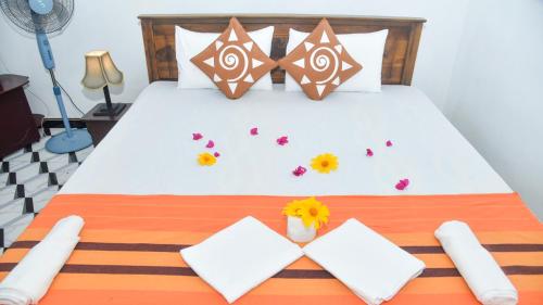 Prem Nadee Hotel في دامبولا: غرفة نوم بها سرير عليه زهور