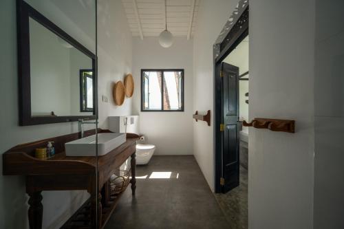 La salle de bains est pourvue d'un lavabo et d'un miroir. dans l'établissement Poya Villa Ahangama by Sunsessions, à Ahangama