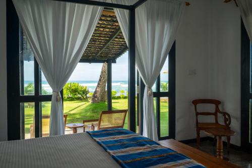 Schlafzimmer mit einem Bett und Meerblick in der Unterkunft Poya Villa Ahangama by Sunsessions in Ahangama